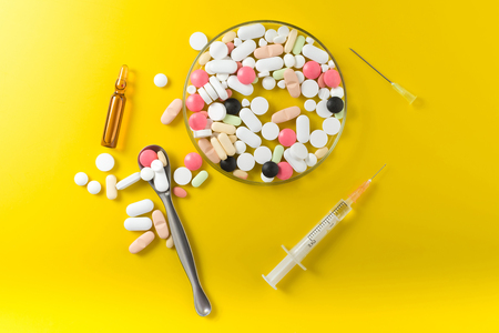 syringe and colorful pill and capsules on backgroundの写真素材