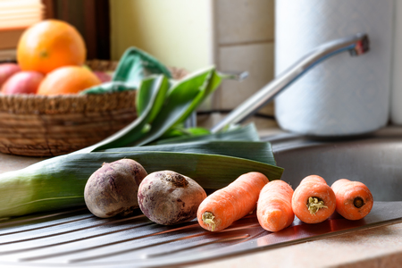 Fresh carrots and beets on the sink in the kitchenの写真素材