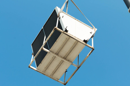 Air compressor on roof of factory with blue sky background.