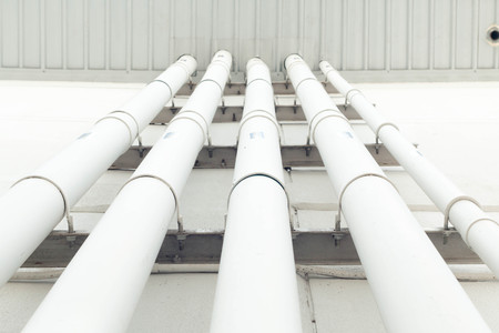 Workers are water pipes with PVC joints Elbow allows the split to the left or right, which must penetrate concrete walls to make PVC pipe coming out the other side of the building.の写真素材