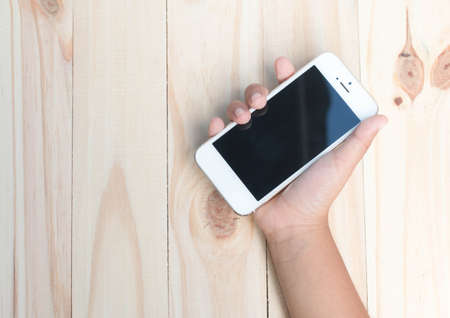 Coffee on vintage wooden table with smart phoneの写真素材