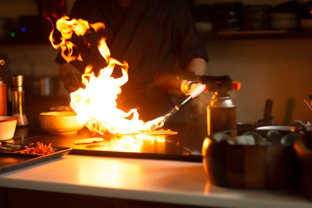 Chef cooking with fire in kitchen at home. Cooking concept.の写真素材