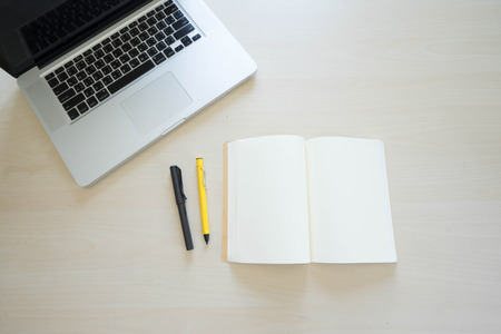 Office table with laptop, book pen , pencils and phoneの写真素材