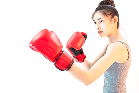 Young beautiful asian woman wore gray sports clothing and red boxing glove isolated on white backgroundの写真素材