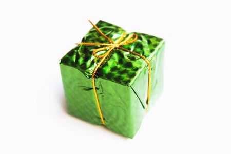 Selective focus,Colorful Gift box wrapped in shiny foil, tied with gold thread.isolated on white background,Christmas day and New Year's giftsの写真素材
