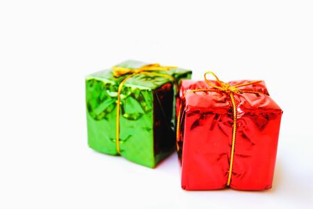 Selective focus,Colorful Gift box wrapped in shiny foil, tied with gold thread.isolated on white background,Christmas day and New Year's giftsの写真素材