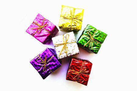 Selective focus,Colorful Gift box wrapped in shiny foil, tied with gold thread.isolated on white...