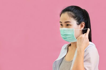 Young asian woman wore a gray tank top, Blue shirt and protective masks against virus and air...