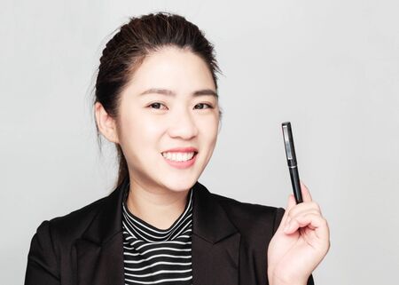 Young smart beautiful asian business woman wore black suit and glasses,smart and thinking holding Document, talking phoneの写真素材