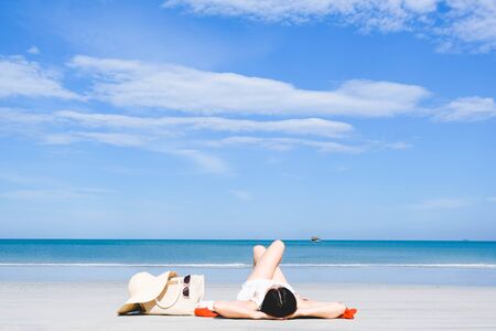 young beautiful asian woman on the beach,standing running sitting lying with hat white dress...