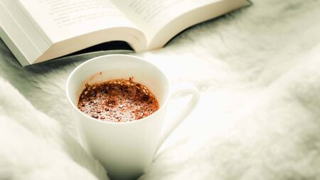 Coffee mugs and books on the bed selective focusの写真素材
