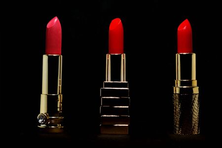 Red lipstick in gold slipcover on black background make up and cosmetic conceptの写真素材