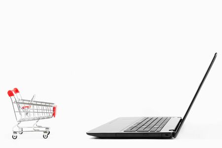 the laptop  and red shopping cart isolated on white background with copy spaceの写真素材