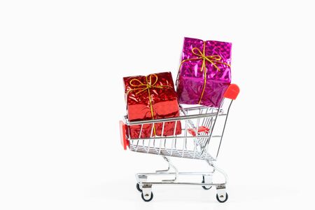 Red and pink gift box in the shopping cart with a copy space isolated on white background,selective focusの写真素材