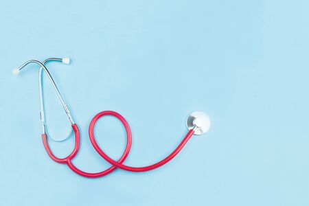 Red stethoscope isolated on blue background with copy space,health care conceptの写真素材