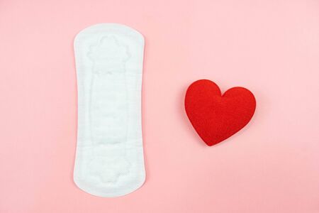 Top view white sanitary napkin and red heart isolated on pink background. Woman hygiene, Concept of critical days, menstruation,health careの写真素材