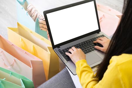 Young woman on sofa and many color shopping bag Order online with laptop,e-commerce from/at home, payment of financial management concept, digital lifestyle with technologyの写真素材
