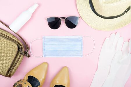Safe travel from viruses concept,(Hat,sunglasses,shoes,bag) with Medical face mask,white latex medical gloves and spray alcohol isolated on pink background ,health care conceptの写真素材