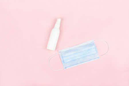 Medical face mask and alcohol spray bottle on pink background,health care conceptの写真素材