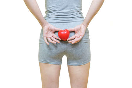 low body of a woman in gray clothes put her hands and red heart on the bottom, Health-care concept on white backgroundの写真素材