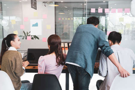 Back of Senior male manager on the job training his colleague in the team for new project and work planning,teach trainee new worker learning new skill at workplace,supervising or teamwork conceptの写真素材