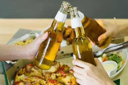 Eat at home by ordering through the delivery service,Selective focus Delicious pizza,wine,BBQ Chicken Wings and a salad next to itの写真素材