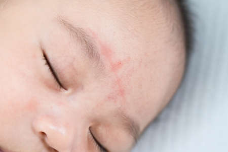 Portrait of a beautiful 4 months newborn smiling, on white background.Cute baby boy smiling.