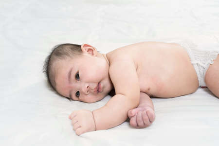 Portrait of a beautiful 4 months newborn smiling, on white background.Cute baby boy smiling.の写真素材
