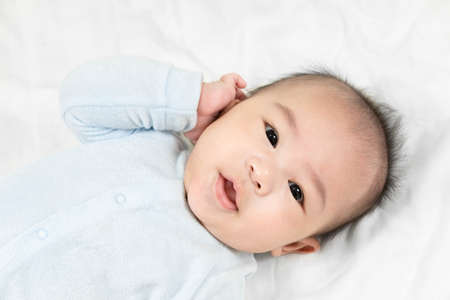 Portrait of a beautiful 4 months newborn smiling, on white background.Cute baby boy smiling.の写真素材