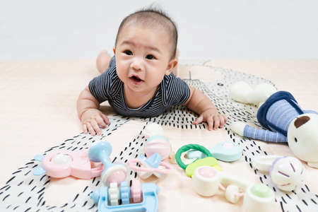 Adorable smiling happy asian baby boy having fun with toys on play mat. Happy healthy kid playing on floor with mobile educational toys. lifestyle concept. authentic childhoodの写真素材