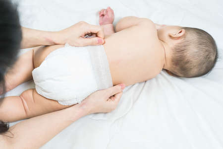 Cute baby massage back in bed, child and health concept.Baby massage and exercises.の写真素材