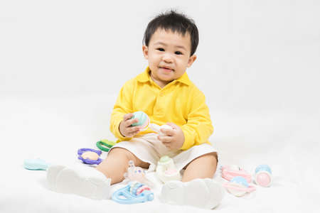 Asian cute baby boy about one year old in yellow shirt playing educational toys have fun smile and laugh happily isolated on white Selective focus.の写真素材