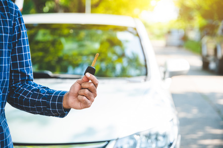 Hand man getting his key outside car. Concept of rent car or buying car.の写真素材