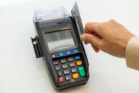 Closeup moment of payment with a credit card machine. Cashless paying for shopping concept. Buy and...