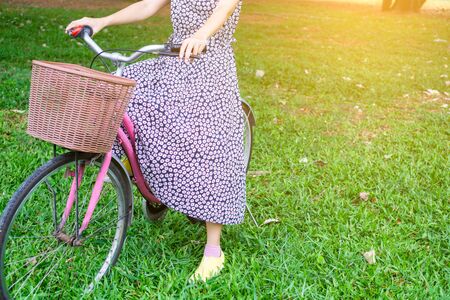 Beautiful woman is riding the bicycle in the park. Relaxing concept.の写真素材