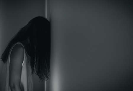 Female ghost in white dress in room. A young scary girl in an old white dress staring in to the...