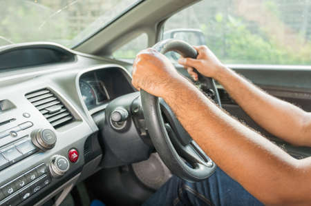 Hands male driving in her car.