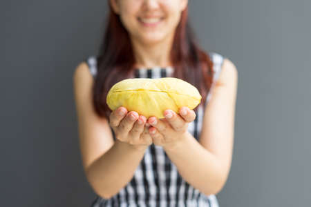 Close up A woman handle durian show the yellow durian meat to eat. The durian is a king of fruit of Thailand.の写真素材
