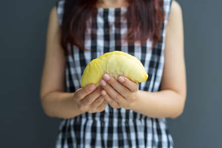 Close up A woman handle durian show the yellow durian meat to eat. The durian is a king of fruit of Thailand.の写真素材