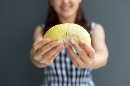 Close up A woman handle durian show the yellow durian meat to eat. The durian is a king of fruit of Thailand.の写真素材