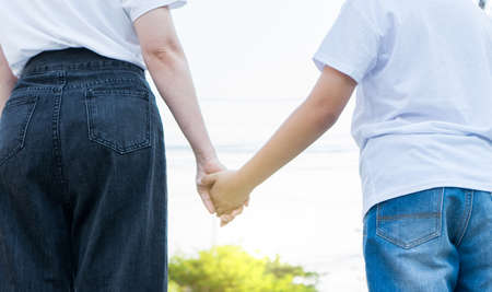 Close up mother holding hand of her son.の写真素材