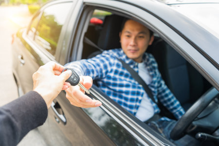 Young asian man getting his key in the car. Concept of rent car or buying car.