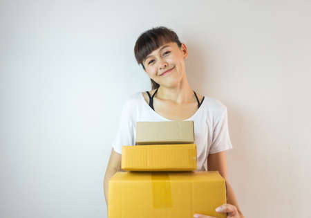 Asian woman smiling carrying three cardboard boxes. Startup small business conceptの写真素材