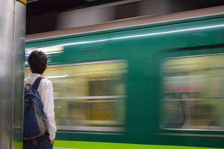 A man waiting for train in subway to back home.の写真素材