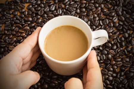 Hot latte coffee cup on coffee beans background.の写真素材