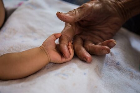 Hand of woman touching senior woman in clinic.の写真素材