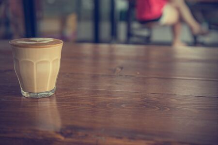 coffee latte cup on a wood table -vintage effect style picturesの写真素材