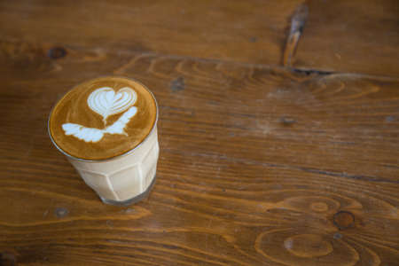 coffe latte cup on a wood tableの写真素材