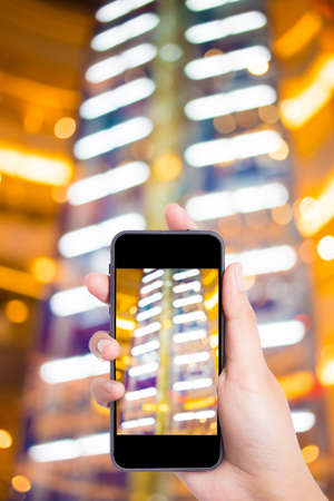 Women hand holding blank mobile smart phone and City night light blur bokeh background.の写真素材