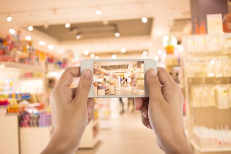 Women in shopping mall using mobile phone.の写真素材